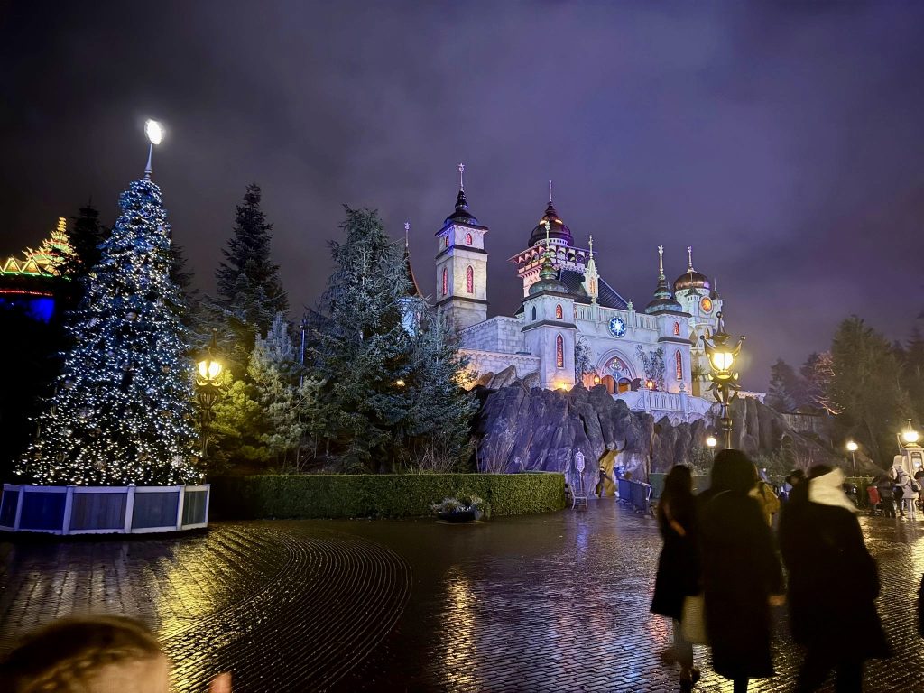 A castle and a Christmas tree in an amusement park in the winter.