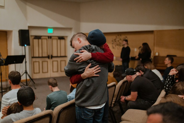 People hugging to support mental health and wellbeing while coping with homesickness.