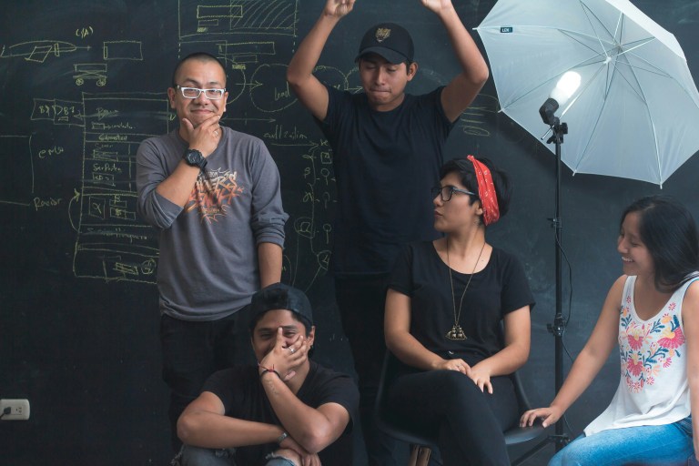 People standing in front of a black board, representing company's employee retention strategies work.
