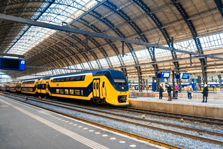 Amsterdam train station representing modern commuting benefits and an effective commute policy for employees in the Netherlands.