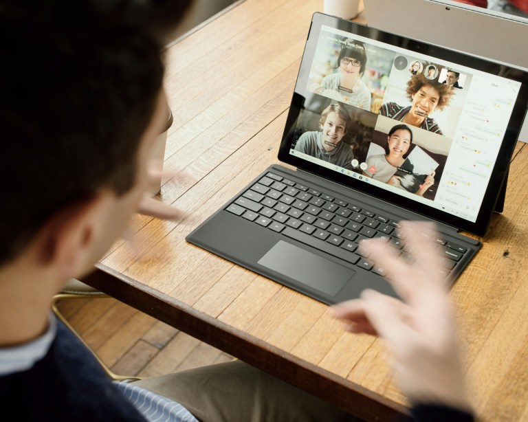 A person joining a Zoom meeting during virtual team building activities with colleagues online.