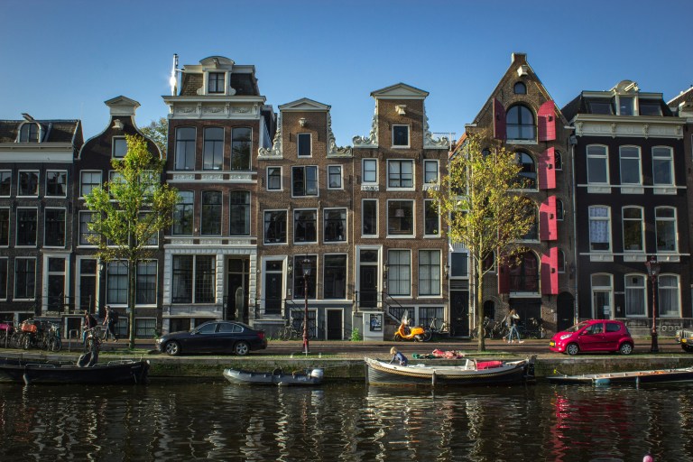 Amsterdam cityscape with historic canals and a cultural heritage centre supporting living traditions and cultural dialogue.