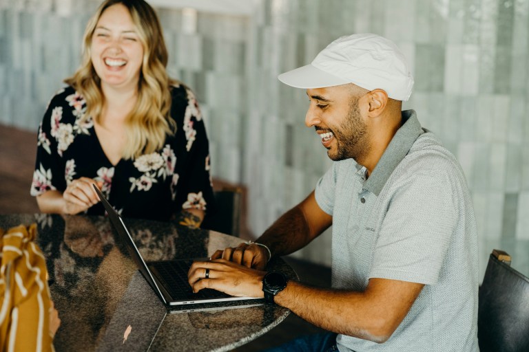 Two professionals setting up payroll for international employees on a laptop