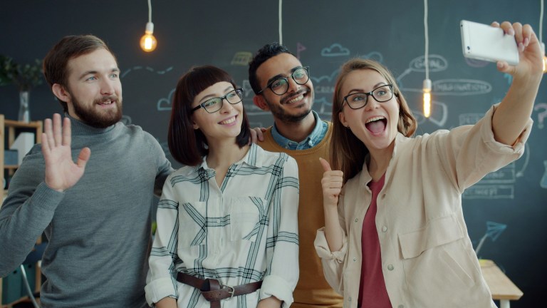 Happy employees in office representing quality employee retention strategies.