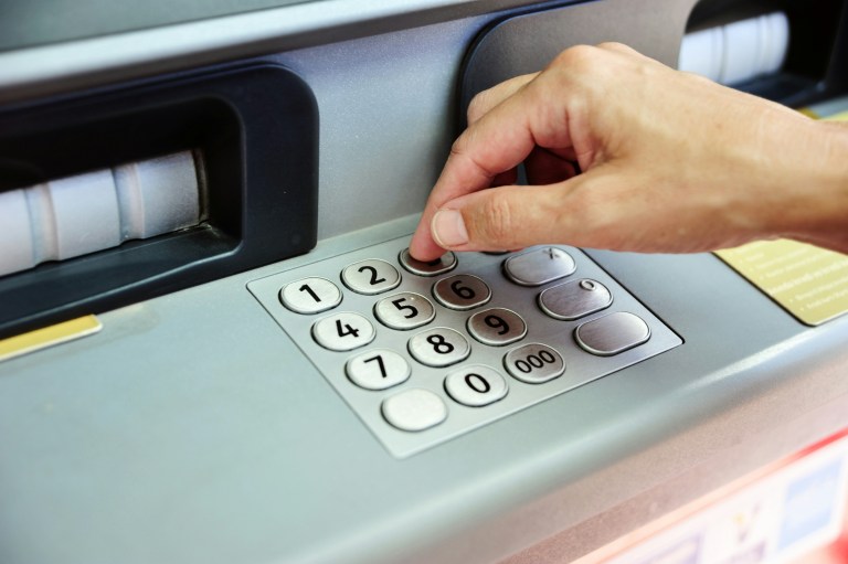Expat using a bank ATM representing opening a Dutch bank account as an expat.