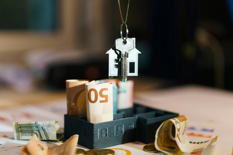 Money and a decorative house keychain representing expats mortgage Netherlands home loan 2026
