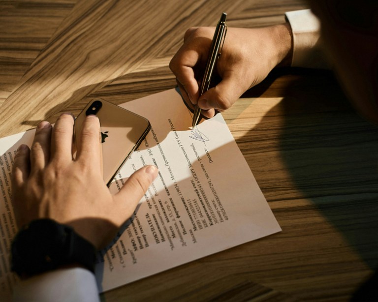 Foreign employer reviewing Dutch CAO compliance paperwork at an office desk.